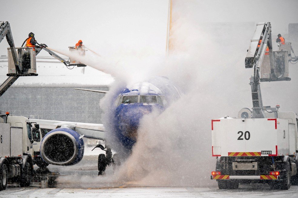 Uma equipe de degelo trabalha durante a tempestade de inverno Fern em uma aeronave da Southwest Airlines no Aeroporto Internacional de Nashville, nos EUA.