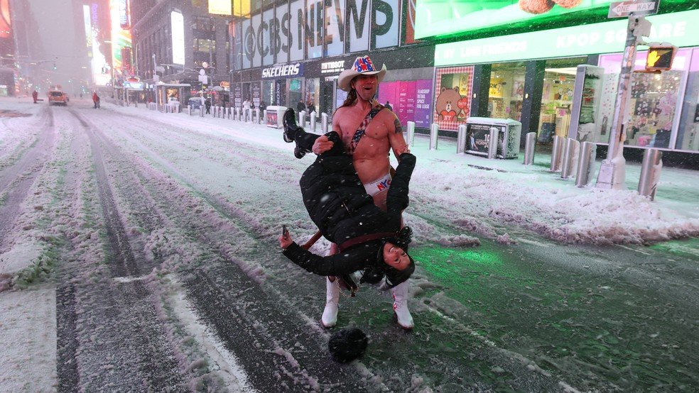 O Cowboy Nu segura uma mulher na Times Square durante uma tempestade de inverno em Manhattan, Nova York, em 23 de fevereiro de 2026.