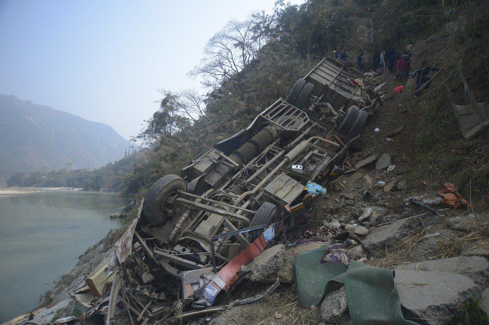Os destroços de um ônibus são vistos na margem do rio Trishuli, após o veículo ter saído da pista em uma rodovia montanhosa perto de Benighat, a oeste da capital, Katmandu, Nepal.