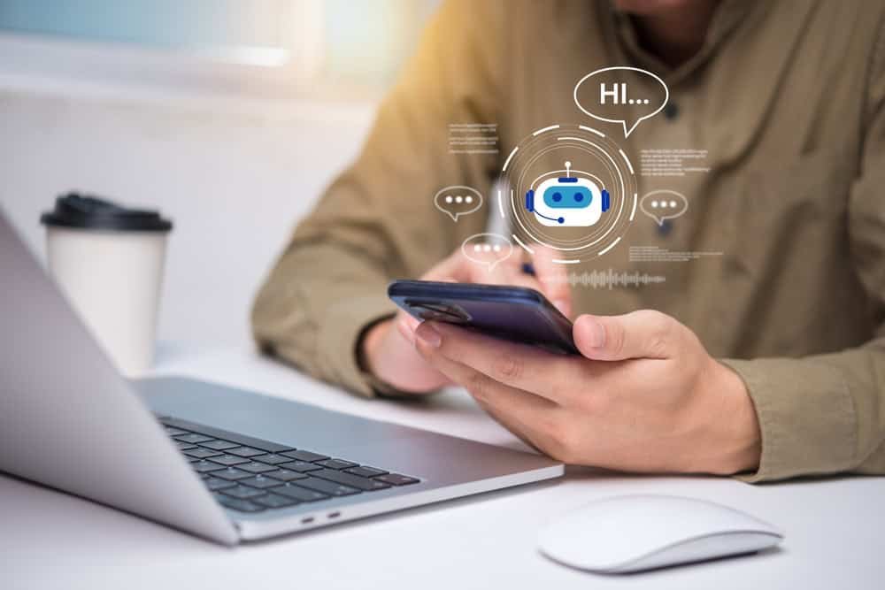 Homem usa celular; chatbot.