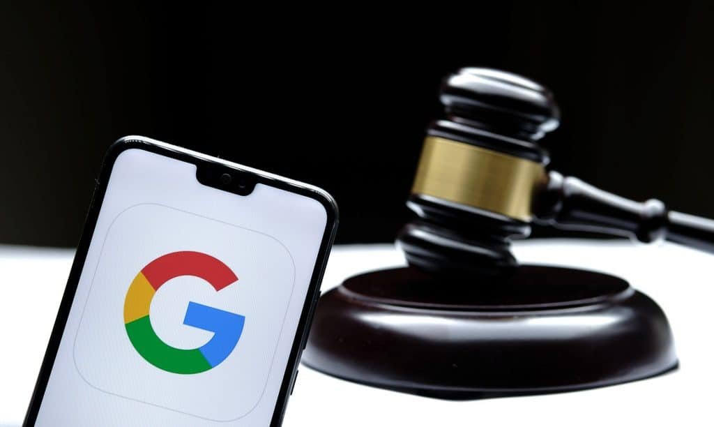 Ícone do Google em um smartphone ao lado de um martelo de juiz