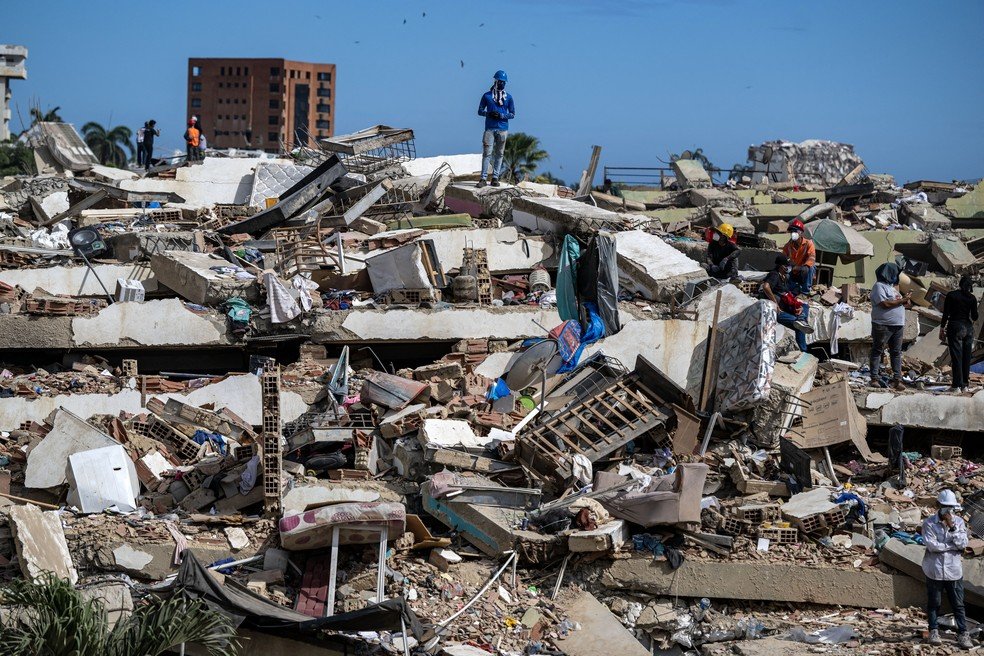 Voluntários buscam sobreviventes em meio a escombros de prédios destruídos por terremotos em Caraballeda, no estado de La Guaira, na Venezuela, em 28 de junho de 2026.