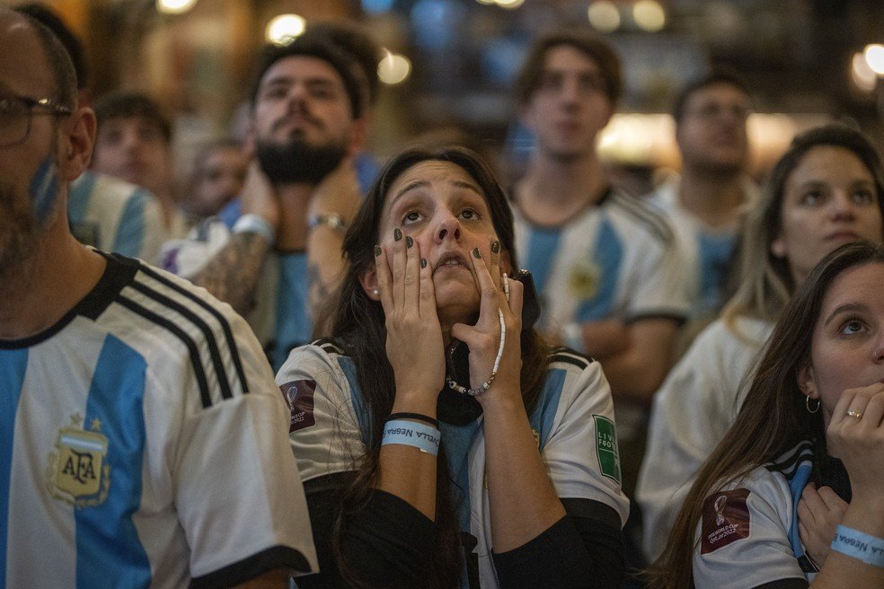 Torcedores argentinos torcem em um bar em Barcelona durante a final da Copa do Mundo.
