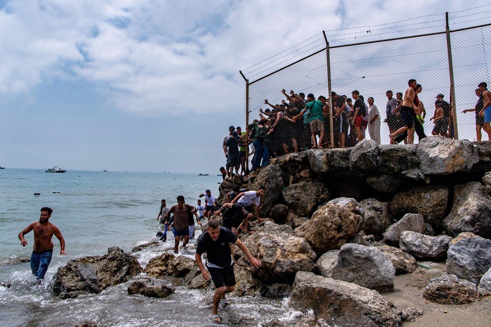 Migrantes entram em Ceuta, enclave espanhol no norte da África, vindos do Marrocos.