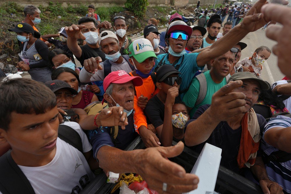 Pessoas recebem suprimentos de voluntários em La Guaira, na Venezuela, em 30 de junho de 2026