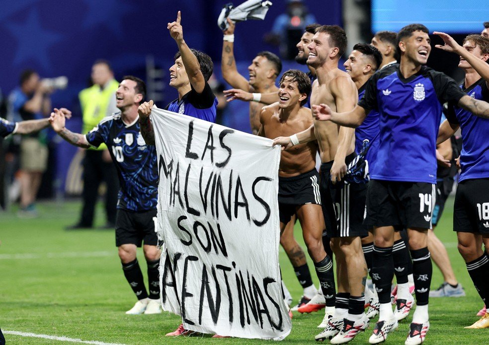 Jogadores argentinos levando faixa com referencia às ilhas Malvinas após eliminarem a Inglaterra da Copa do Mundo de 2026.